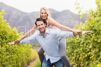 Young happy man carrying happy woman on his back