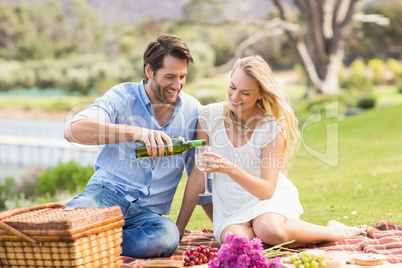 Cute couple on date pouring wine in a glass
