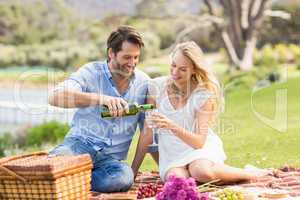 Cute couple on date pouring wine in a glass