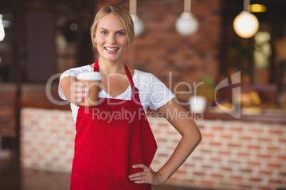 Pretty waitress handing a mug of coffee