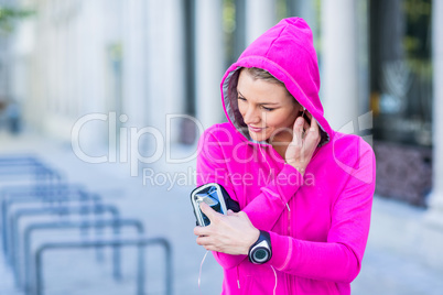 A woman wearing a pink jacket using her phone