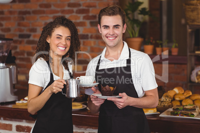Waiter and waitress smiling at camera