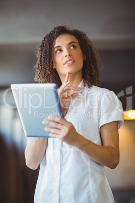 Thoughtful woman using a digital tablet