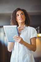 Thoughtful woman using a digital tablet