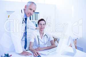 Portrait of smiling medical colleagues working with computer and