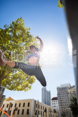 Athletic woman leaping and holding arms up in the air