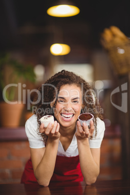 Laughing waitress showing two cupcakes