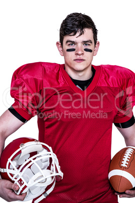 American football player holding helmet and a ball