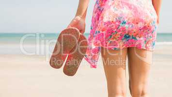 Stylish woman standing on the sand