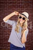 Gorgeous smiling blonde hipster posing with straw hat