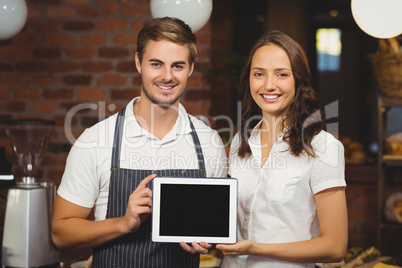 Smiling co-workers showing a tablet