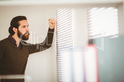 Hipster businessman looking out the window