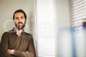 Hipster businessman leaning beside window