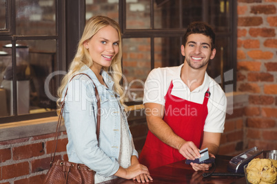 Smiling waiter swiping the credit card