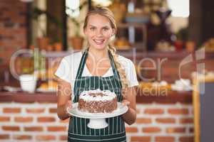Pretty waitress holding a chocolate cake