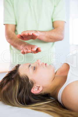 Relaxed pregnant woman getting reiki treatment