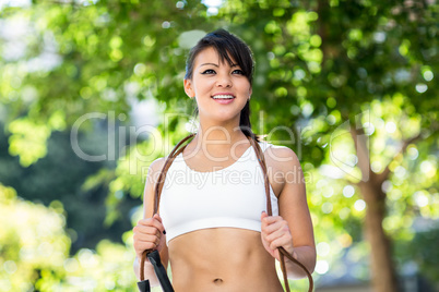 Smiling athletic woman with skipping rope