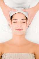 Attractive woman receiving facial massage at spa center