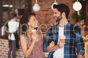 Smiling hipster couple with take-away cups