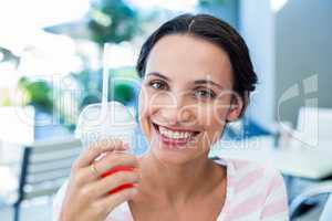 Smiling brunette woman enjoying her milkshake