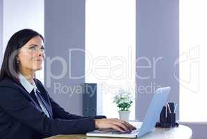 Businesswoman working on laptop at her desk