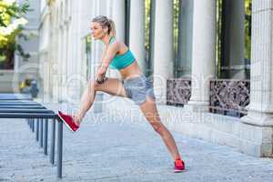 A beautiful woman stretching her leg against pipes