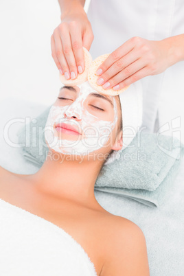 Hands cleaning womans face with cotton swabs