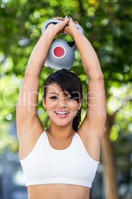 Portrait of smiling athletic woman lifting kettlebell Portrait of smiling athletic woman lifting kettlebell