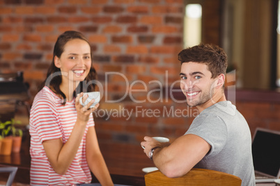 Smiling friends drinking coffee