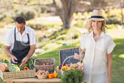 Blonde customer holding a vegetables basket