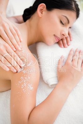 Woman enjoying a salt scrub massage