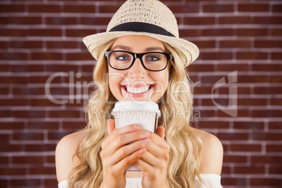 Gorgeous smiling blonde hipster with take-away cup