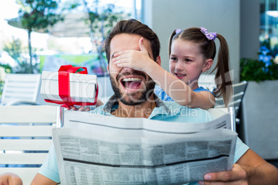 Daughter offering her present to her dad