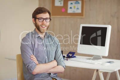 Happy hipster sitting at his desk