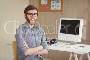 Happy hipster sitting at his desk