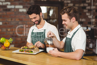 Two smiling baristas working at the counter