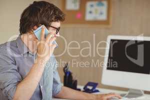 Hipster businessman on the phone at desk