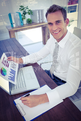 Smiling businessman working with flow charts