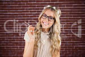 Gorgeous smiling blonde hipster holding pen