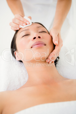 Hands cleaning woman face with cotton swabs