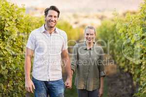 Two young happy vintners holding hands