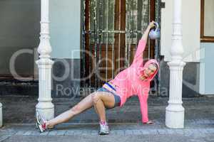 A pretty woman in a pink outfit with a weight