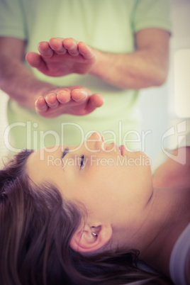 Relaxed pregnant woman getting reiki treatment