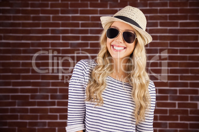 Gorgeous smiling blonde hipster with sunglasses and straw hat