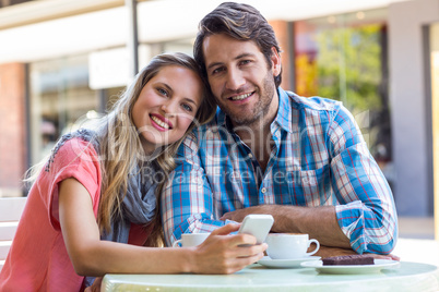 Smiling couple having tea in a cafe