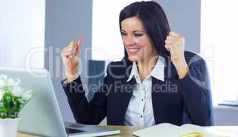 Businesswoman cheering at her desk