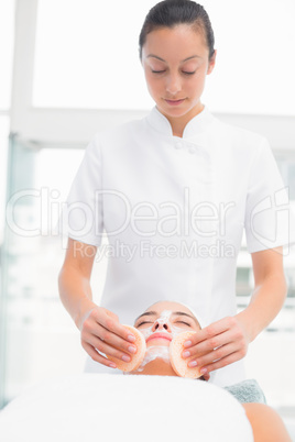 Hands cleaning woman woman face with sponge