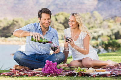 Cute couple on date pouring red wine