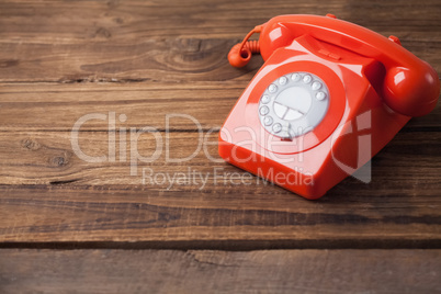 Red telephone on wooden table