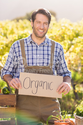 Smiling farmer holding an organic sign